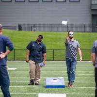 A bag being launched in the air in a cornhole match between two Facilities teams